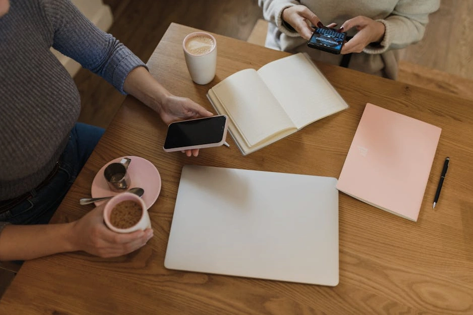 Osoba píšící do poznámkového bloku během porady.